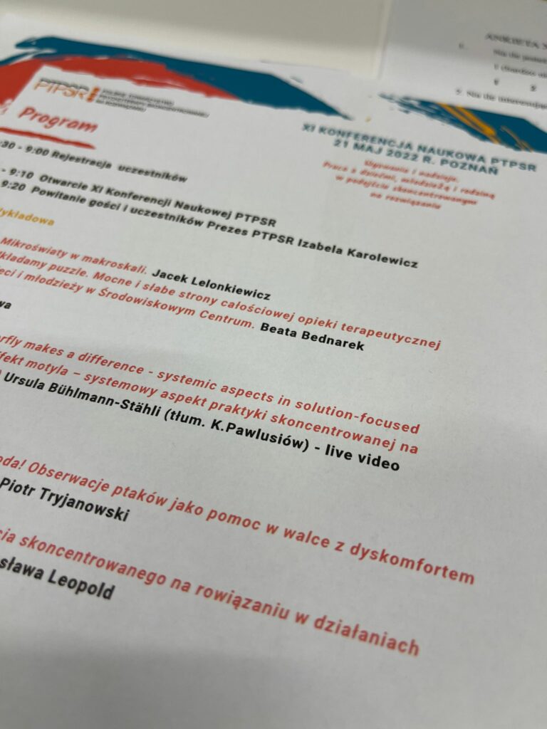 Na zdjęciu na białym tle czerwone napisy o programie konferencji 